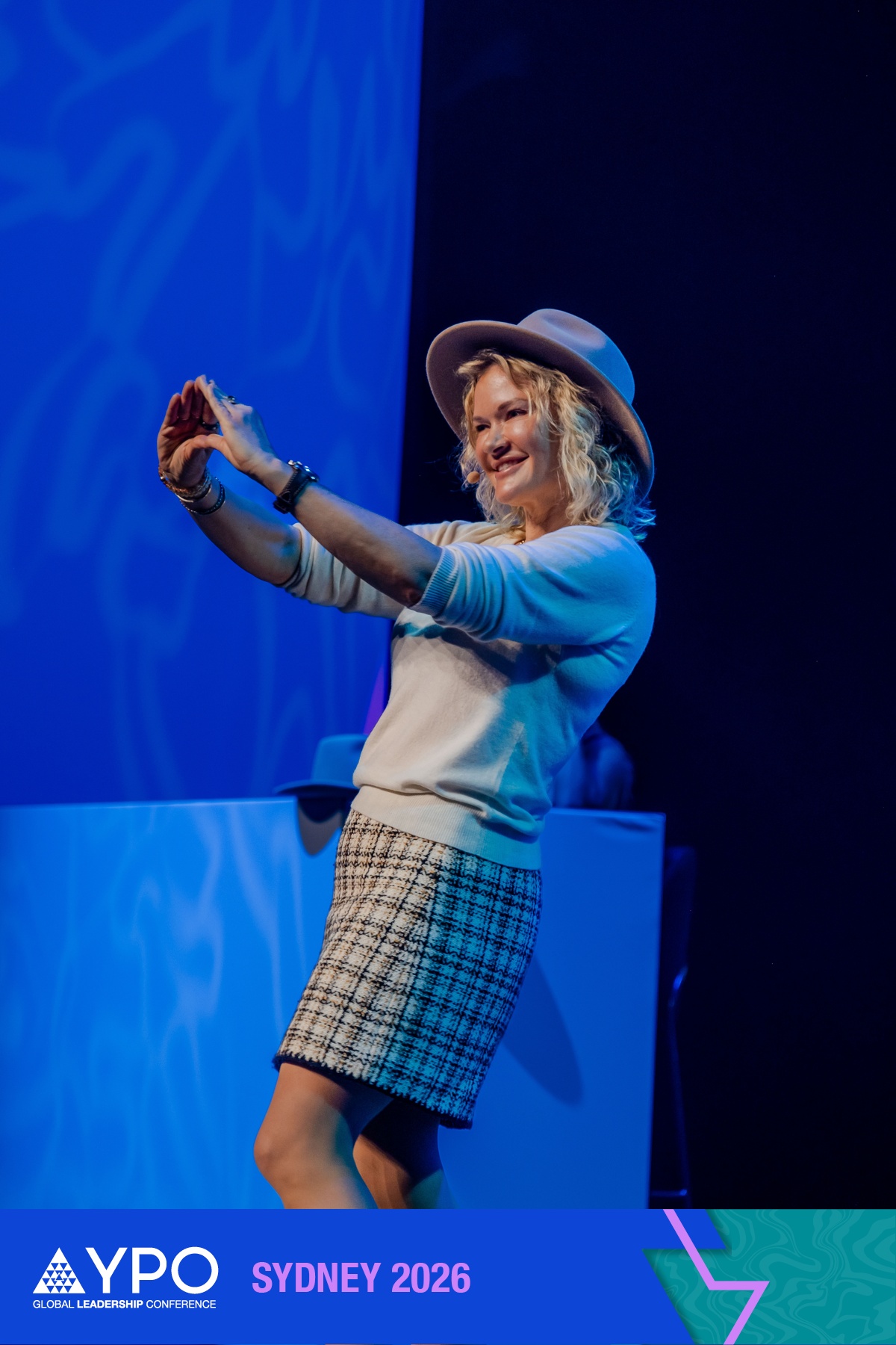 Amber Allen making a heart shape on stage